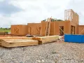 Budowa domu z płyty OSB. Konstrukcja z drewna i płyt OSB, materiały budowlane na placu.