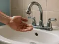 Dłoń łapie kropelki wody z kranu. Woda ledwo kapie, zastanawiam się, ile bar ma woda w kranie.
