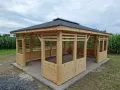 Nowa altana ogrodowa całoroczna z drewnianymi ściankami i czarnym dachem, idealna na każdą pogodę.