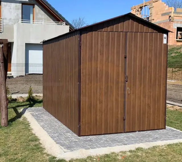 Solidny fundament pod domek narzędziowy, wykonany z kostki brukowej, zapewnia stabilność i estetykę.