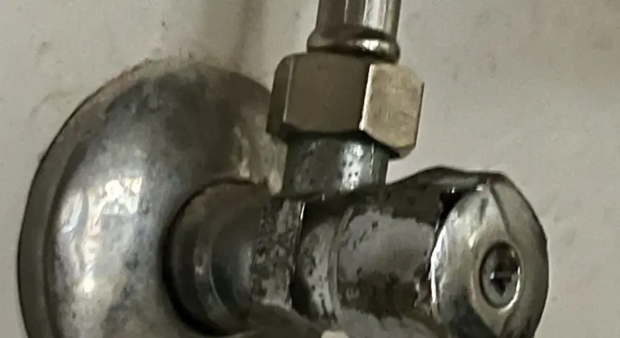 Metalowy zawór wodny, pokazujący, jak odkrecic zawor z woda. Widoczny śrubunek i pokrętło.
